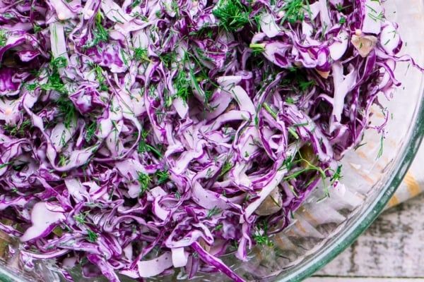 a glass bowl filled with red cabbage salad