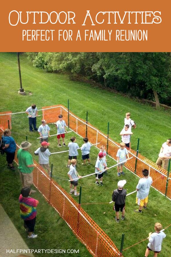 a group of people playing tennis on top of a grass covered field in front of trees