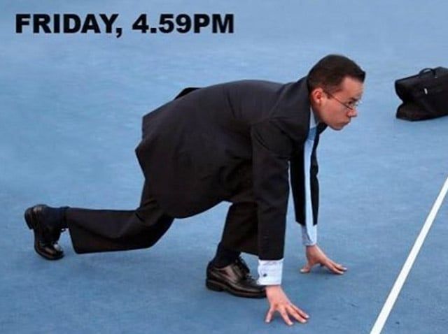 a man in a suit bending over on a tennis court