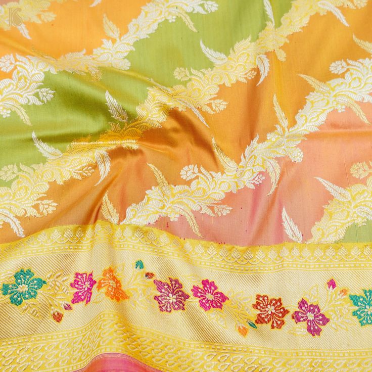 an orange, yellow and green floral print fabric with white flowers on the bottom half