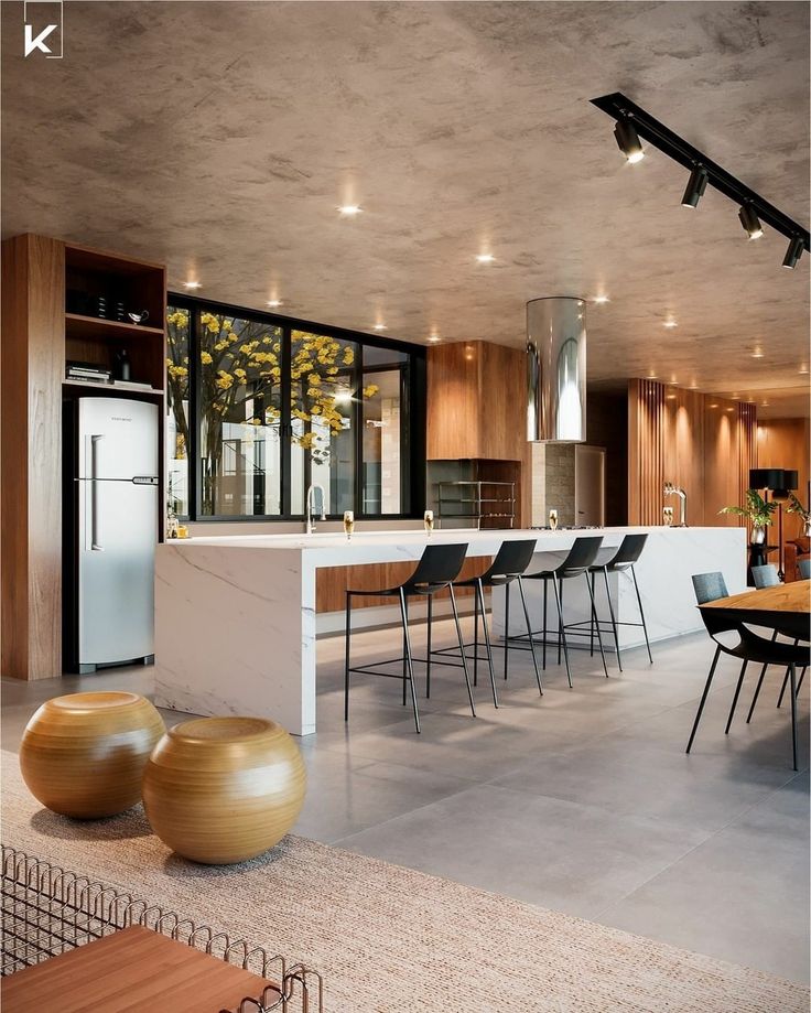 a modern kitchen and dining room with large windows in the backround, surrounded by wooden accents