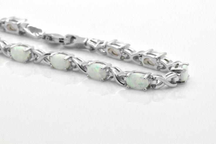 Here we have a beautiful lab created White Opal Sterling Silver tennis Bracelet. Opals feature cabochon oval cut in prong setting. Bracelet is about 5 carats of gemstone total weight. This bracelet was designed to allure and impress. It will be an excellent addition to a jewelry collection due to its unique design. The bracelet is made out of solid 925 Sterling Silver and 14k white gold overlay for that timeless and classic look. Brand new item, never worn. Other lengths available per especial r White Oval Bracelets In Fine Jewelry Style, Sterling Silver Oval Gemstone Bracelet For Anniversary, Oval Sterling Silver Bracelet With Gemstone For Anniversary, Oval Cabochon Bracelet In Fine Jewelry Style, Oval Sterling Silver Bracelet In Fine Jewelry Style, Classic Sterling Silver Bracelet With Oval Gemstone, Fine Jewelry Sterling Silver Oval Bracelet, Oval Sterling Silver Bracelet, Oval Shaped Sterling Silver Bracelet Fine Jewelry