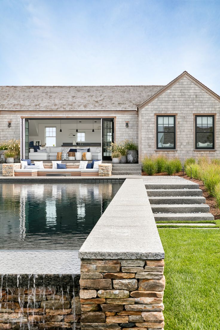 a house with a pool in front of it and water running from the back yard