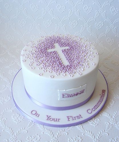 a white cake with purple sprinkles and a cross on the top that says, on your first birthday