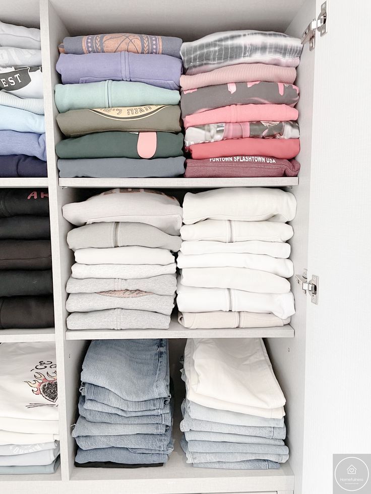 an organized closet with folded shirts and folded pants