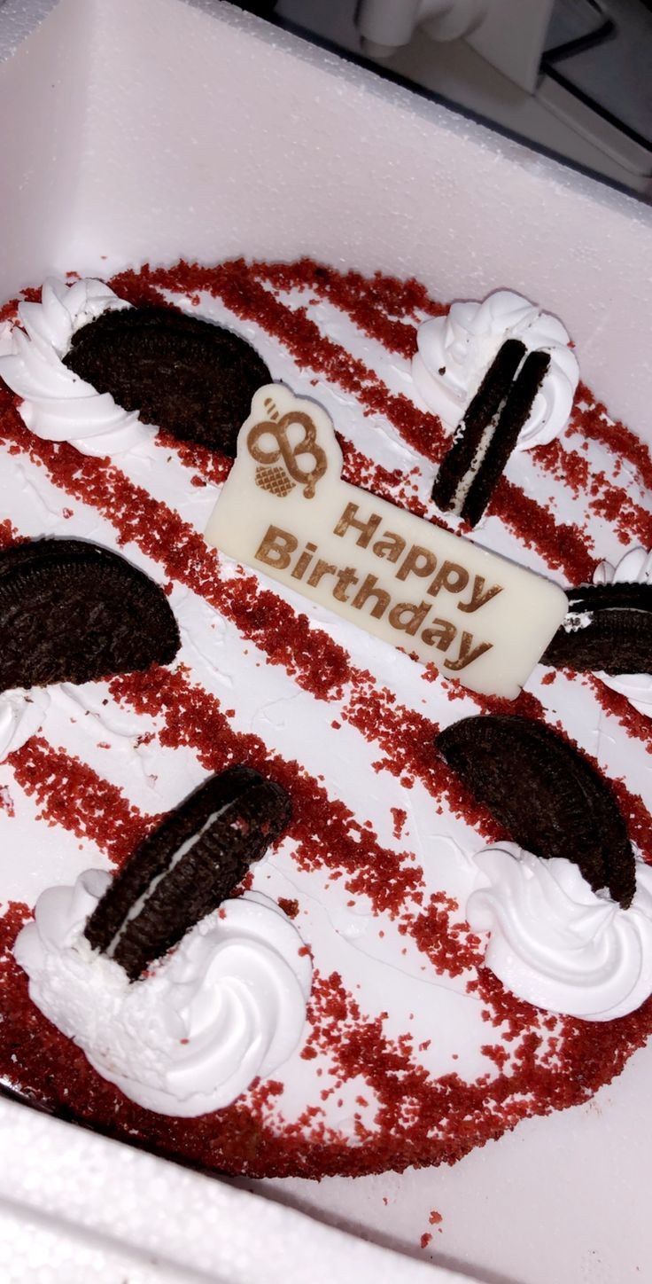 a birthday cake with white frosting and red sprinkles in a box