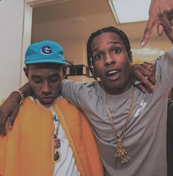 two young men standing next to each other in front of a mirror and pointing at the camera