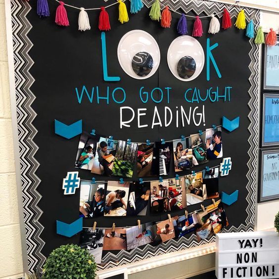 a bulletin board with pictures and tassels hanging on it's side that says look who got caught reading