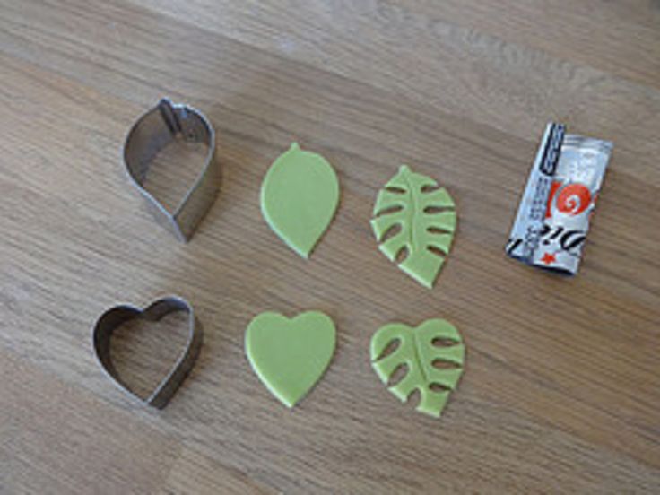 four cookie cutters, one with leaves and the other with heart shaped cookies in front of them