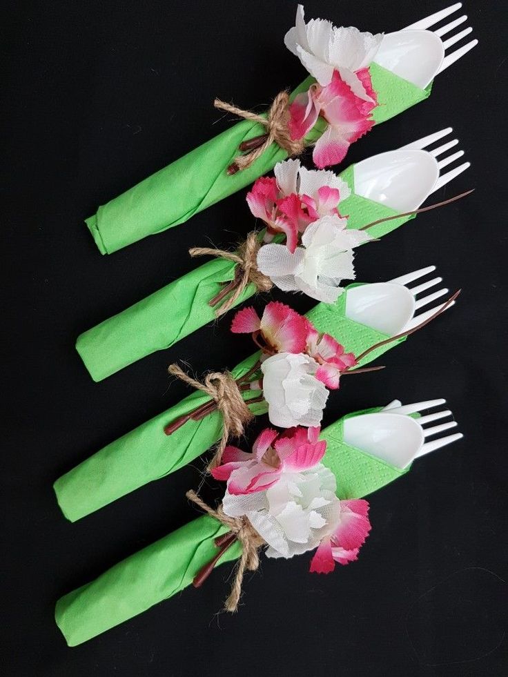 four forks are decorated with flowers and green napkins