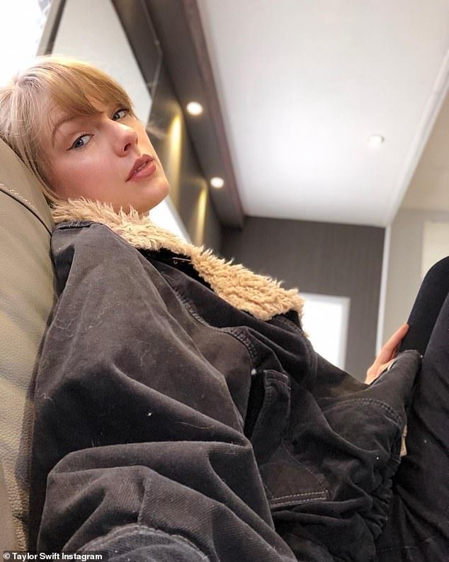 a woman sitting on top of a couch next to a window