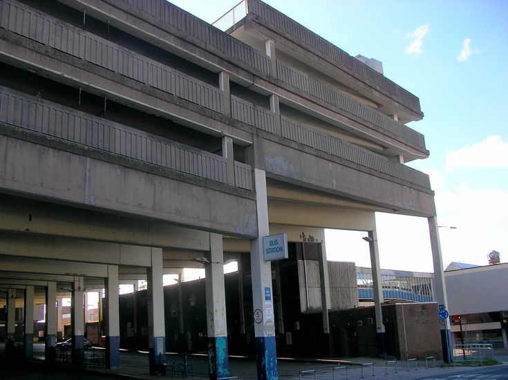 an empty parking garage next to a tall building with balconies on the sides