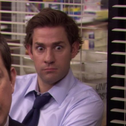 two men in suits and ties sitting at a desk with their hands on their hips