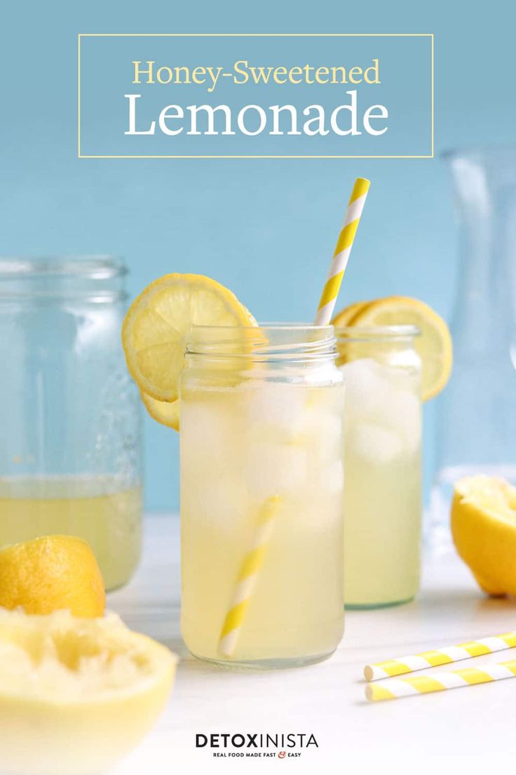 two mason jars filled with lemonade next to sliced lemons and drinking straws