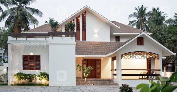 a large white house with lots of windows and plants in front of the door area