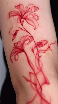 a red flower tattoo on the arm