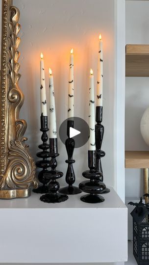 candles are lined up on a shelf in front of a mirror and other decorative items