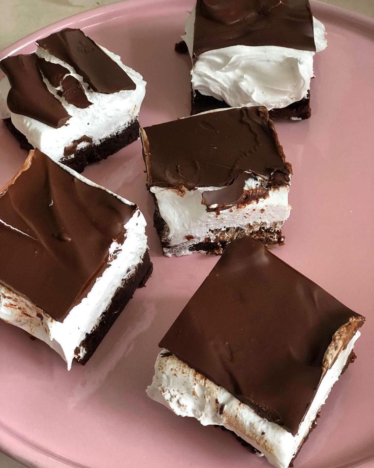 several pieces of chocolate and marshmallow dessert on a pink plate