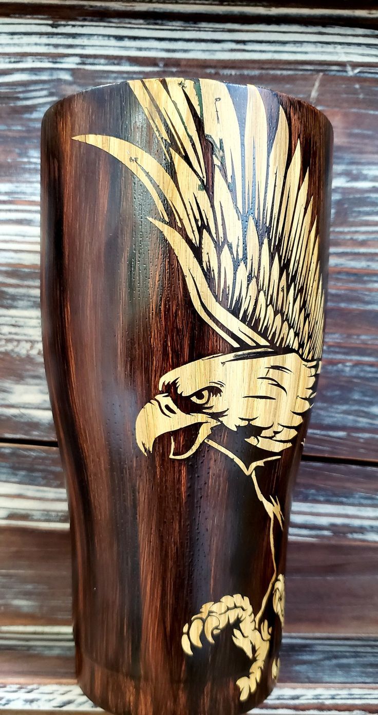 a wooden cup with an eagle painted on it