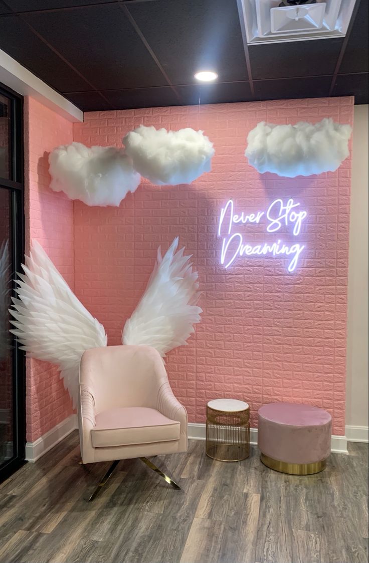 a pink room with angel wings on the wall