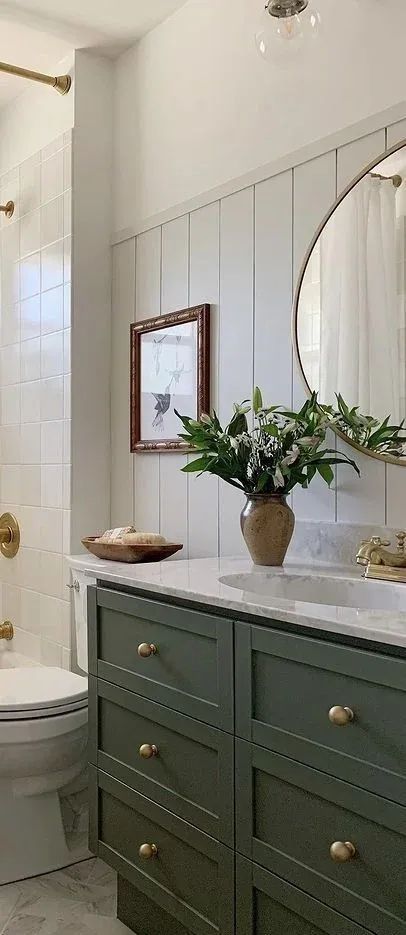 a white toilet sitting next to a green dresser