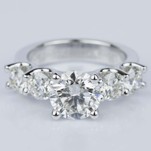 three stone diamond engagement ring in 18k white gold with diamonds on the sides and four prongs