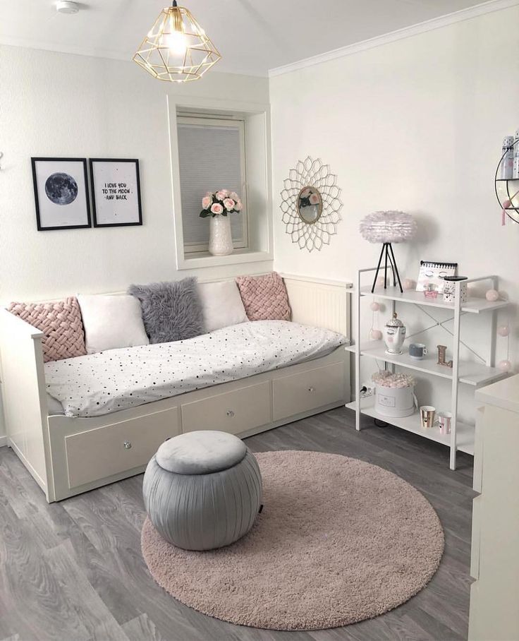 a room with white walls and wood flooring has a pink rug on the floor