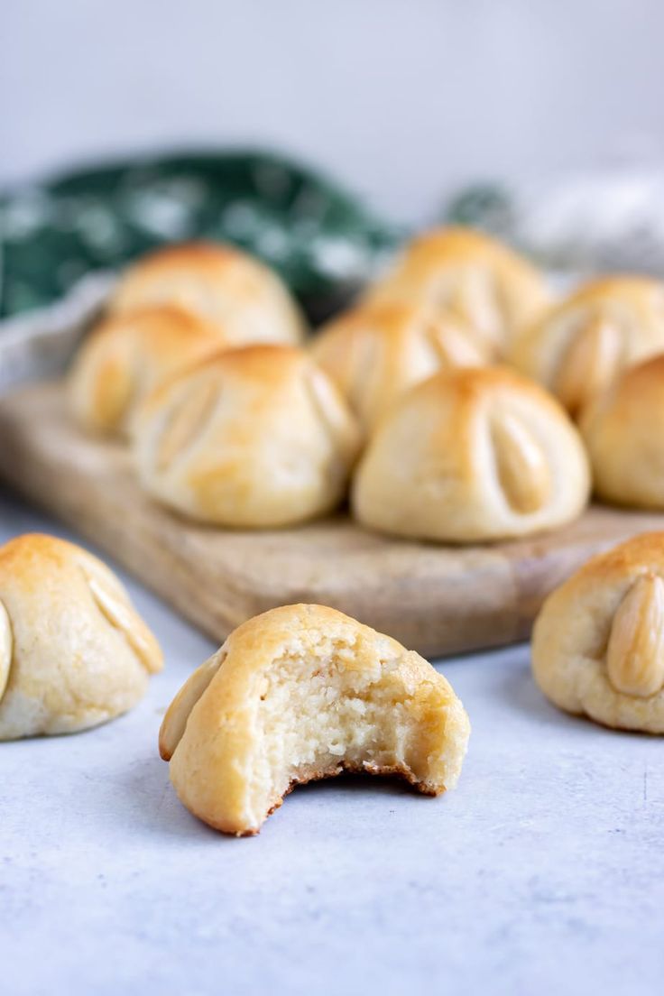 some bread rolls are on a cutting board