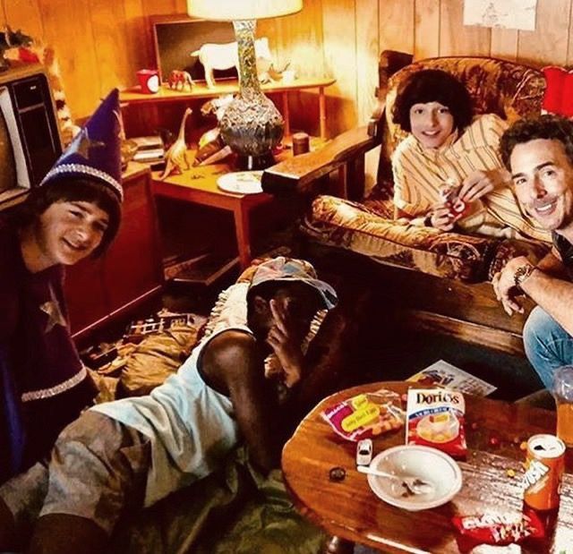 a group of people sitting on top of a couch in a living room next to each other