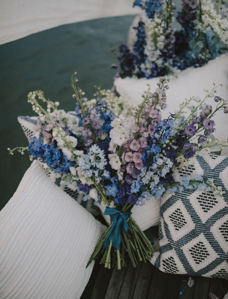 blue and white flowers sitting on top of pillows