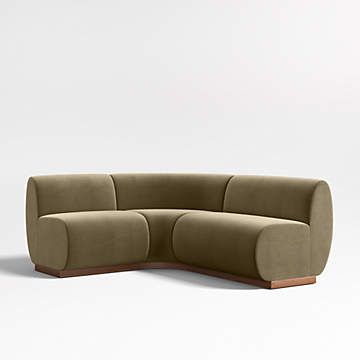 the curved couch is made out of fabric and wood, with a rounded backrest