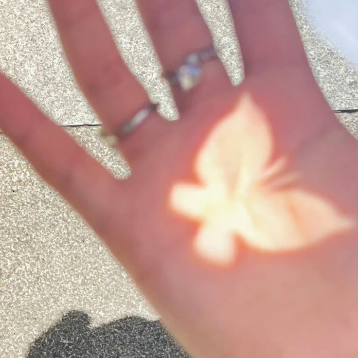 a person's hand with a ring on it and a flower drawn on the palm