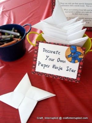 a table topped with lots of paper and craft supplies next to a sign that says decorate your own paper ninja star