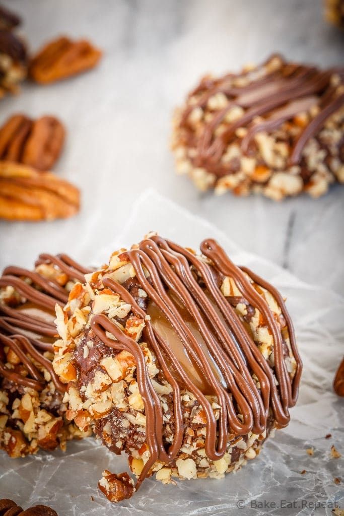 two cookies with chocolate drizzle and nuts on top