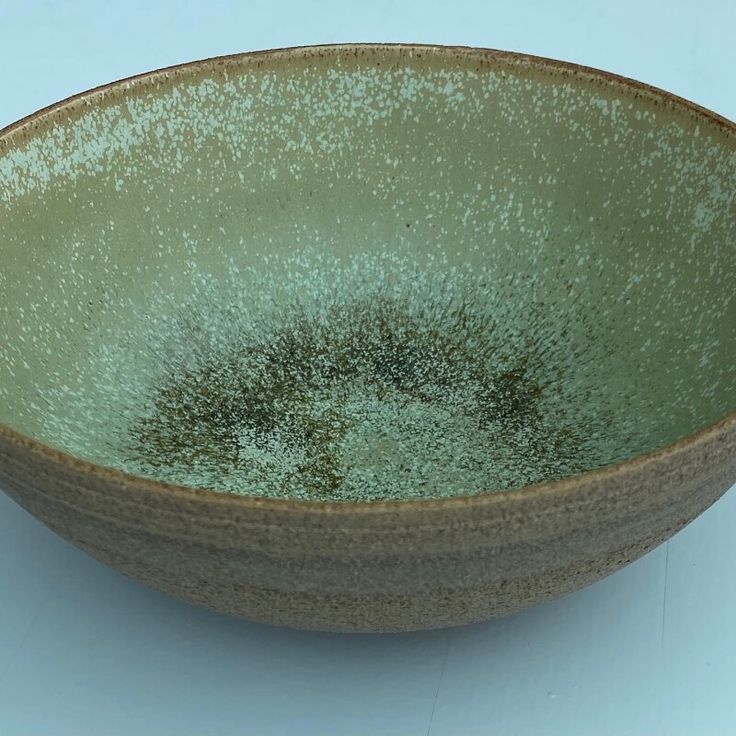 a green bowl sitting on top of a table