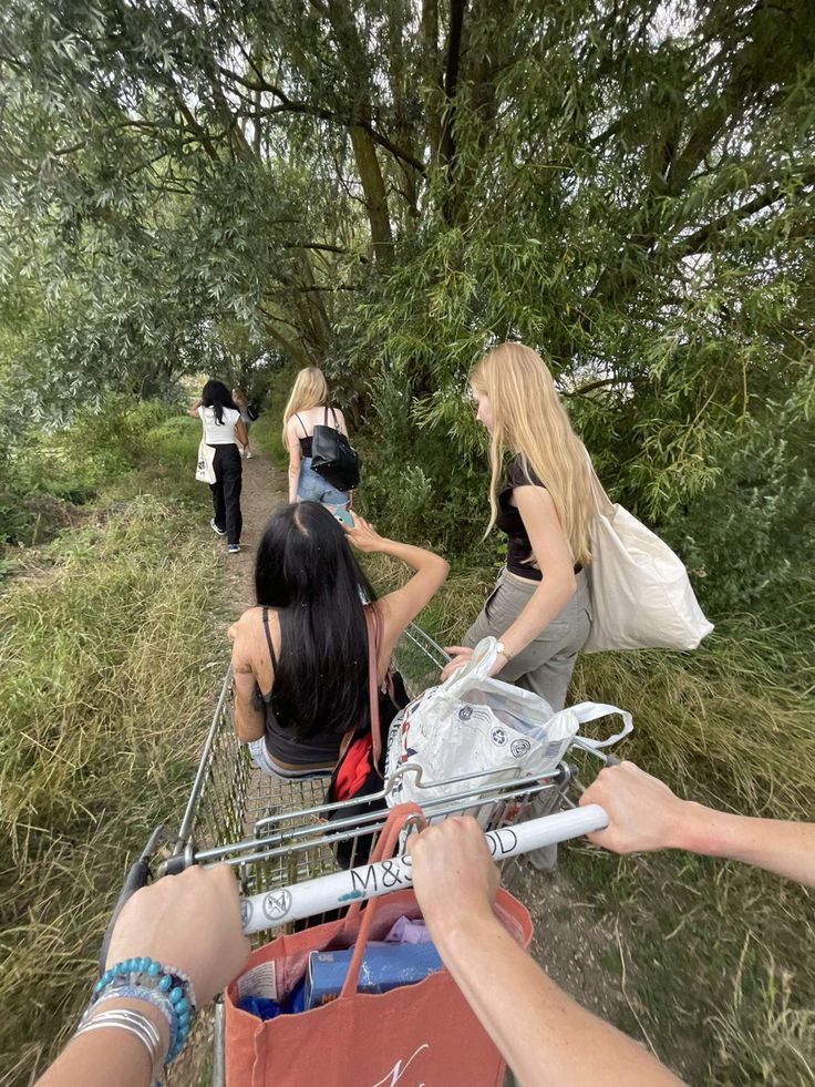 several women are walking down a path with shopping bags