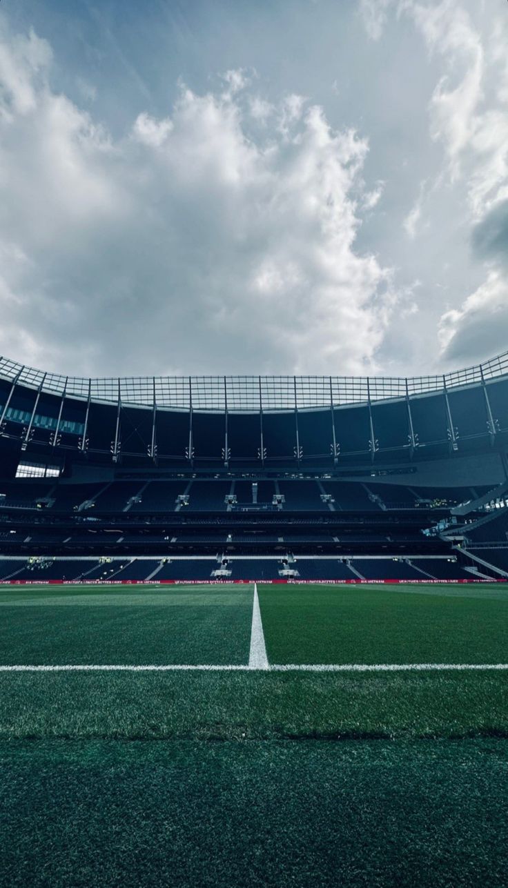 an empty soccer stadium with the sky in the background