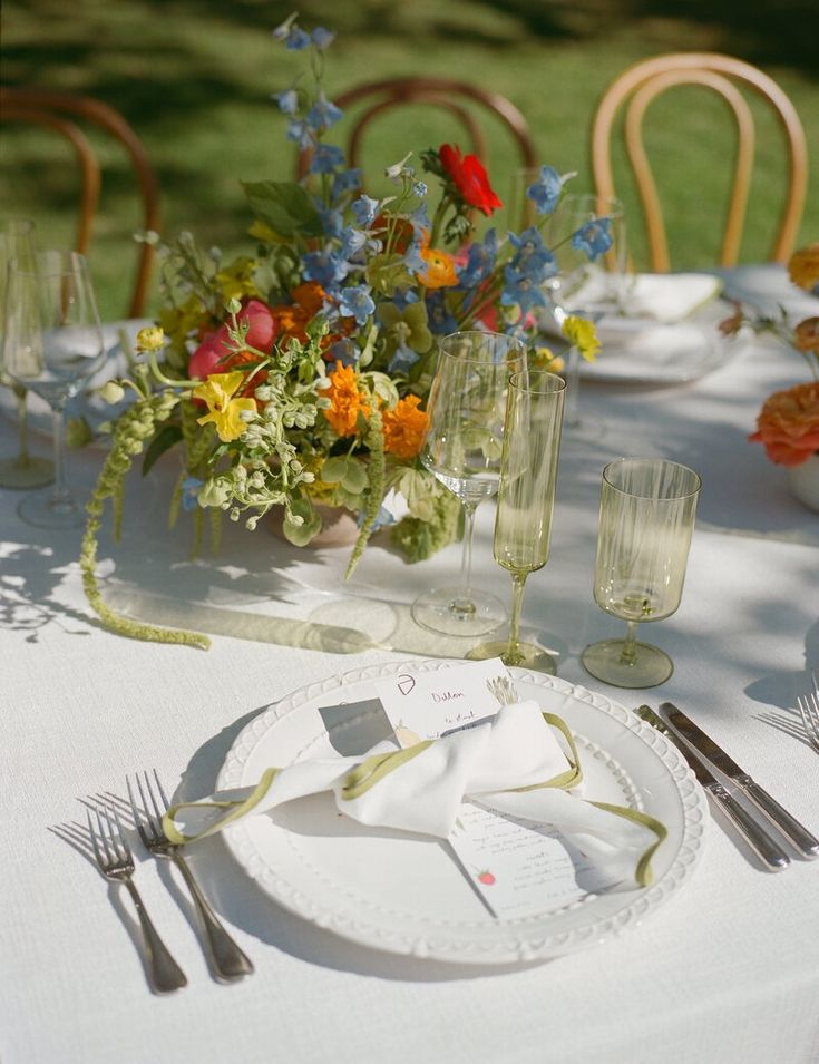 the table is set with flowers and silverware