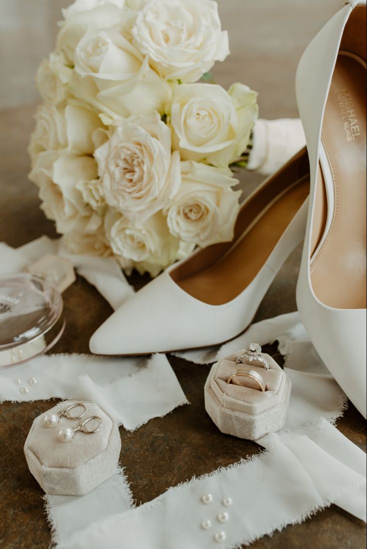 a bouquet of white roses and wedding shoes