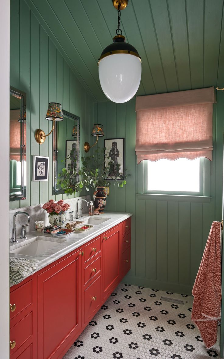 a bathroom with green walls and red cabinets