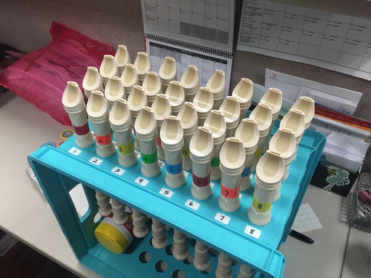 several plastic cups are stacked on top of each other in front of a computer desk