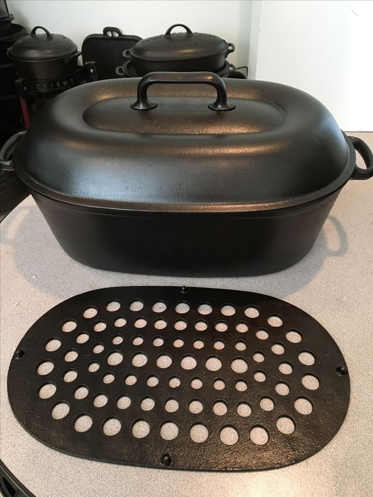 a large black pot sitting on top of a stove next to an oven grate