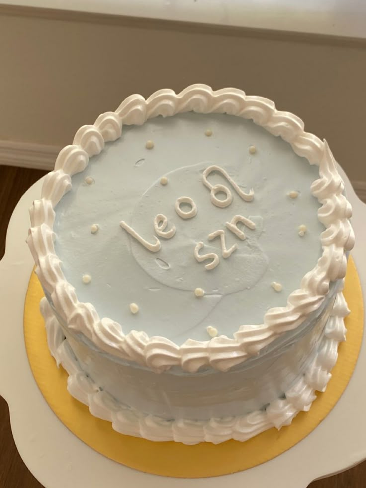 a cake with white frosting that says let go on it sitting on top of a yellow and white plate