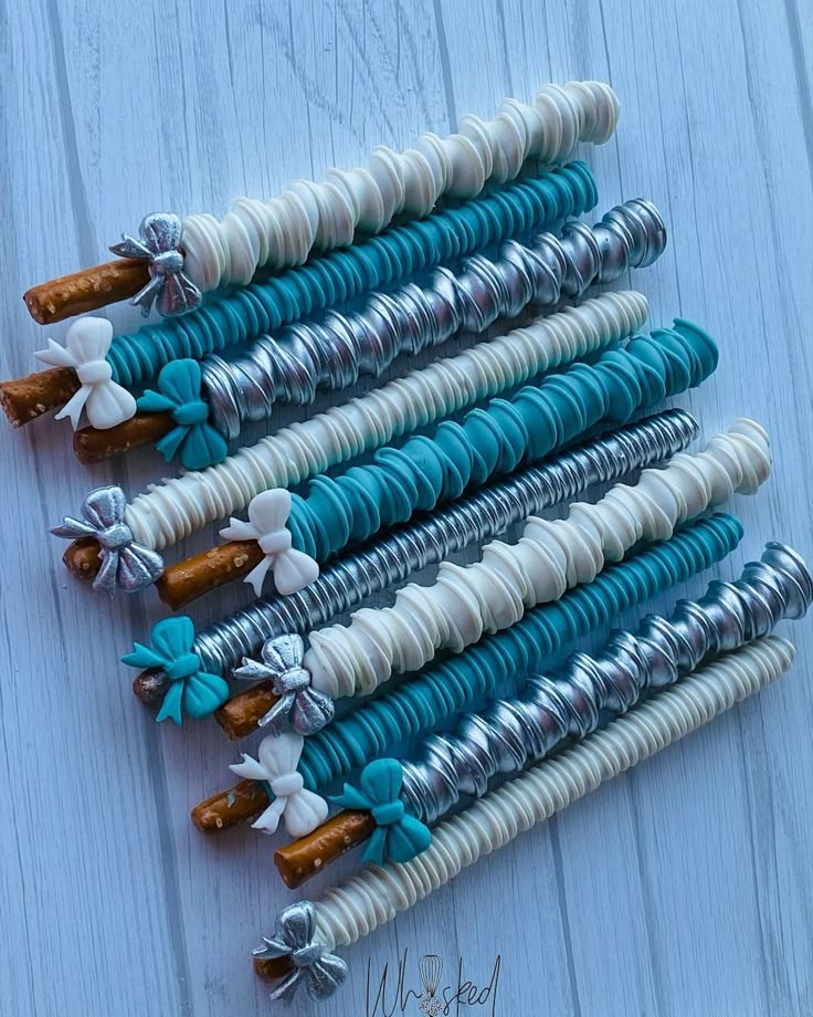 several blue and white decorative objects are arranged in a row on a wooden surface, with ribbons attached to them