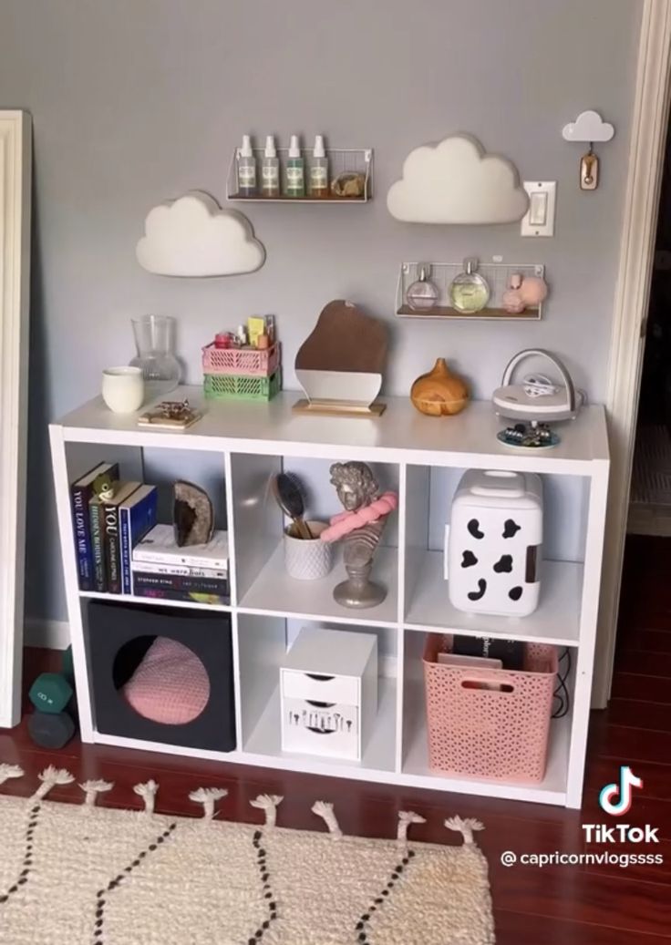 a white shelf filled with lots of different items on top of a hard wood floor