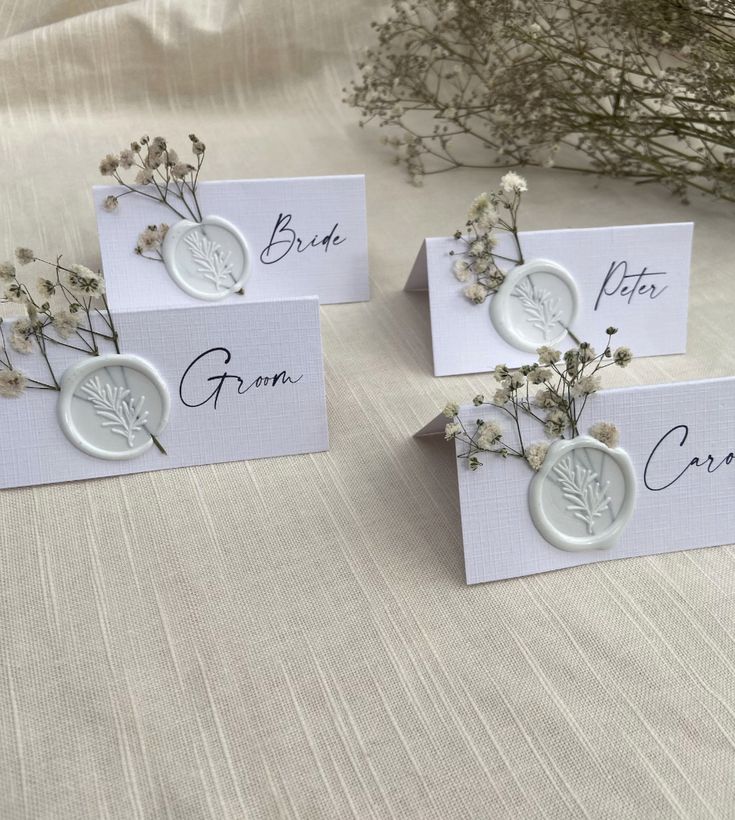 four place cards with dried flowers on them