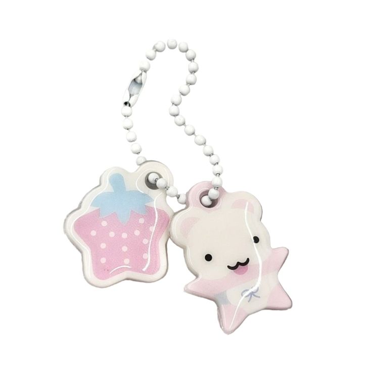 a white and pink keychain with a teddy bear on it's side