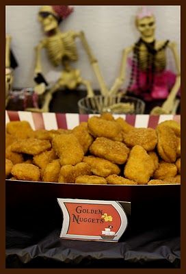 there are two skeletons in the background and some fried food on the table next to them