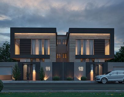 a car is parked in front of a two story house at night with lights on the windows