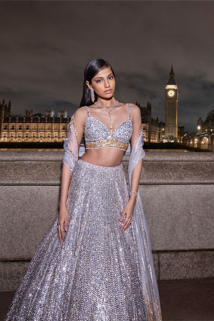 This lehenga set features silver and gold sequins and bead embroidery in a linear pattern. The strappy blouse has crystal droplets at the waist. It is paired with a matching net dupatta.From Seema Gujral's For the love of London collection. DELIVERY TIMEPlease allow 8-12 weeks for your outfit to arrive. FABRIC DETAILSNet Professional cleaning only. Bling Indian Outfits, Glam Party Outfit, Sequence Lehenga, Sequin Lehenga, Diy Fashion Hacks, Indian Lehenga, Cocktail Gowns, Indian Bridal Outfits, Gold Sequin